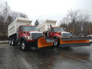 Two Red Concord Road Equipment With Orange Plows With White Dump Beds Raised
